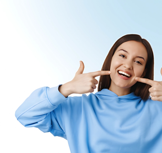 Smiling woman highlighting her clean teeth with both hands