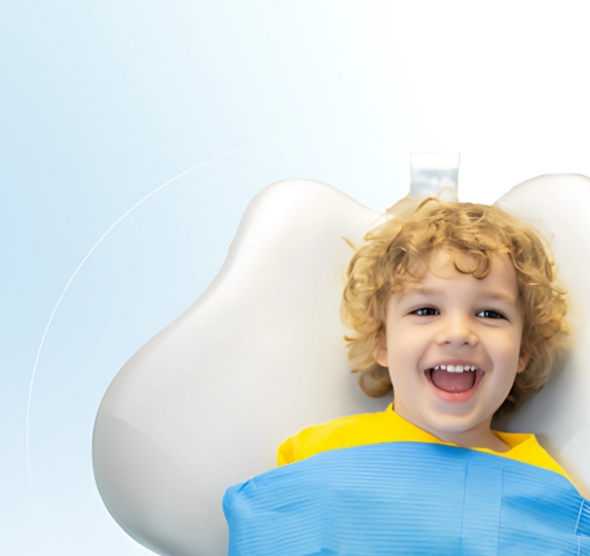 Happy child smiling while sitting on a dental chair