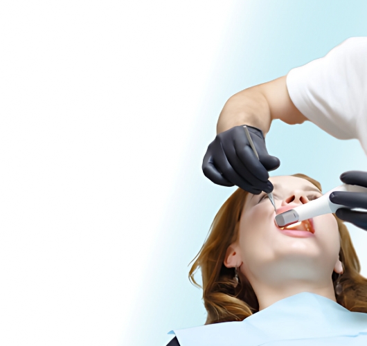 Dentist treating a woman in a dental chair using professional dental tools
